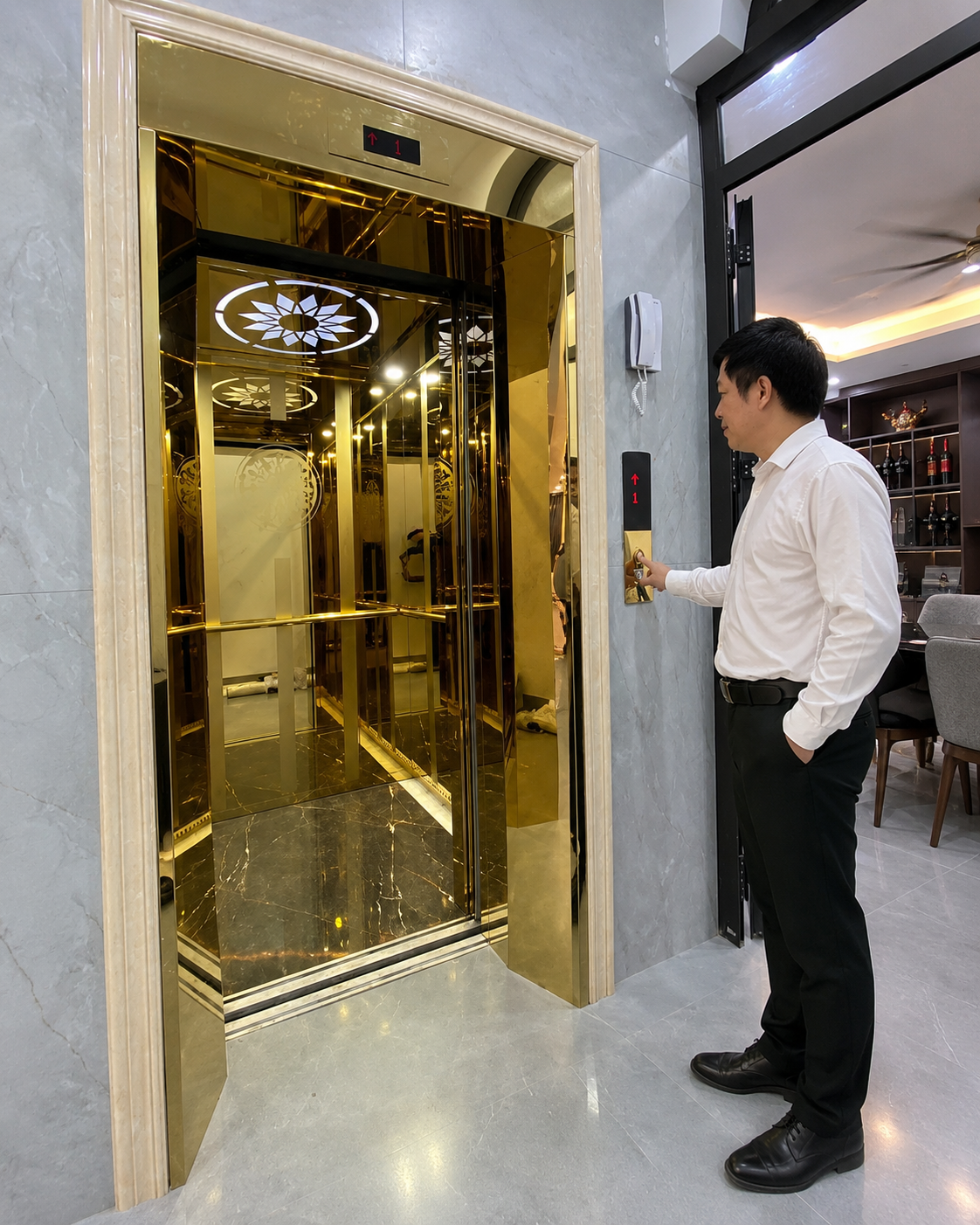Người đàn ông bấm nút gọi thang máy gia đình cửa kính mạ vàng sang trọng trong nhà hiện đại